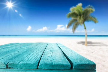 Wooden desk of free space and summer beach with palms 