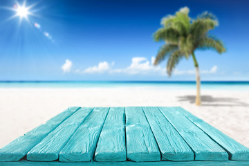 Wooden desk of free space and summer beach with palms 