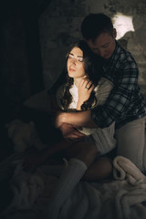 Guy with a girl hugging in bed. bright sunlight on the face