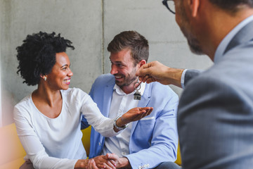 Real estate agent handing over house keys to young married couple