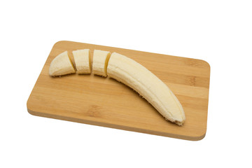 Sliced bananas on wooden cutting board, top view