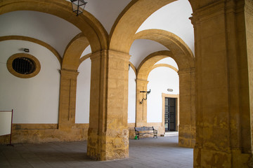Fototapeta na wymiar Entrada de um mosteiro em arcos com um Bnaco para descanso