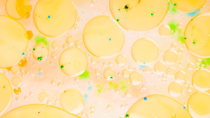 Multicolored background with oil on liquid. Abstract golden green background on liquid. Pattern with multicolored spots. Fluid art