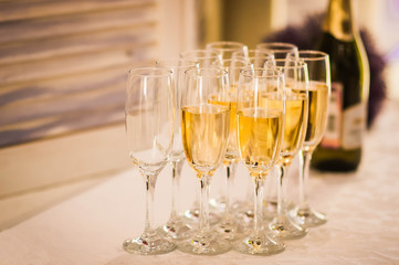 some glasses of champagne with a bottle on the background