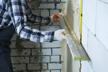 view of builder hands plastering on block wall - obrazy, fototapety, plakaty