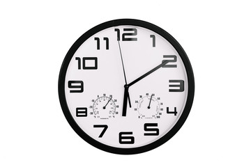 simple classic black and white round wall clock isolated on white. Clock with arabic numerals on wall shows 18:00 , 6:10