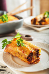 The process of cooking pasta cannelloni close up and copy space. Italian pasta with minced meat, sauce, garlic, tomatoes, parsley