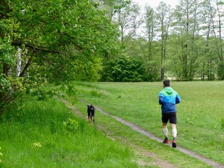 Man running with dog in nature