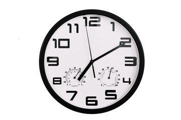 simple classic black and white round wall clock isolated on white. Clock with arabic numerals on wall shows 19:10 , 7:10