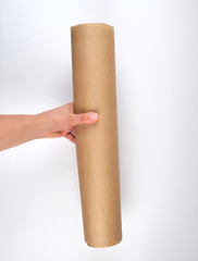 hand hold a large roll of brown parchment paper