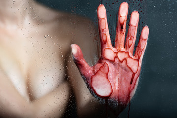 cropped view of nude girl with bleeding hand touching glass in bathroom