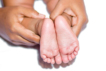 A mom holding baby two feet on a white background