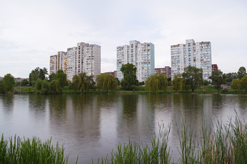 Fototapeta na wymiar View across the lake on three houses near the lake.
