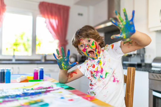 Blond Child Painting With Colored Face Stained