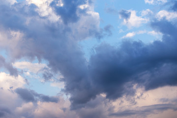 Epic dramatic storm cumulus fluffy clouds in sunlight against blue sky background, heaven texture