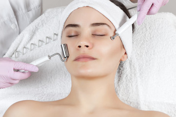 The cosmetologist makes the apparatus a procedure of Microcurrent therapy of a beautiful, young...