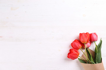 Fresh flower composition, bouquet of red color tulips, textured background. International Women's day, mother's day greeting concept. Copy space, close up, top view, flat lay.