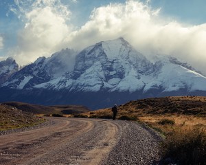 Peaks of Mountains in Torres del Plains National Park Patagonia Chile with person on gravel road