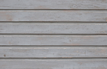 Fototapeta premium The unique texture of narrow white wooden boards, painted with gray oil paint and aged