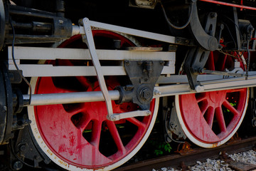 Vintage steam locomotive detail with cranks and red wheels