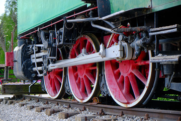 Vintage steam locomotive detail with cranks and red wheels