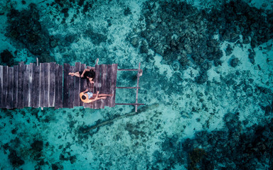 aerial view photography of couple sitting on wood dock