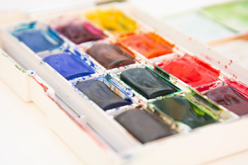 Set of watercolor paints isolated for painting closeup. Selective focus. Art, creative background with copy space.