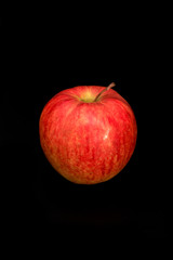 Fresh organic red apple isolated on a black background.