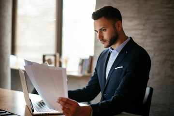 Attractive businessman doing paperwork in the office
