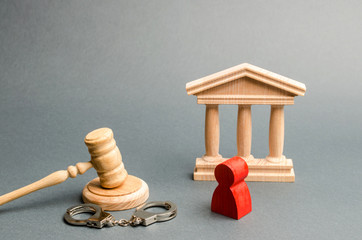 Red figurine of a man at the trial. Protection of the defendant in the criminal case. Protection...