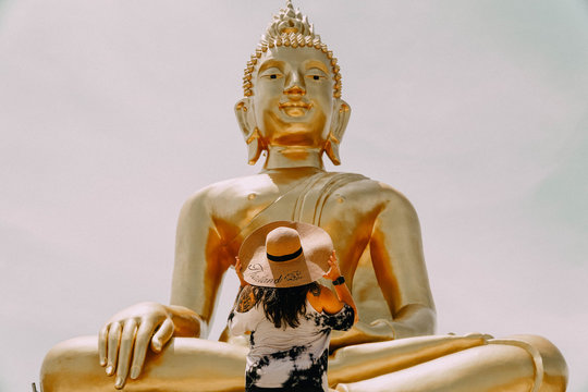 Woman Standing In Front Of Gautama Buddha Statue