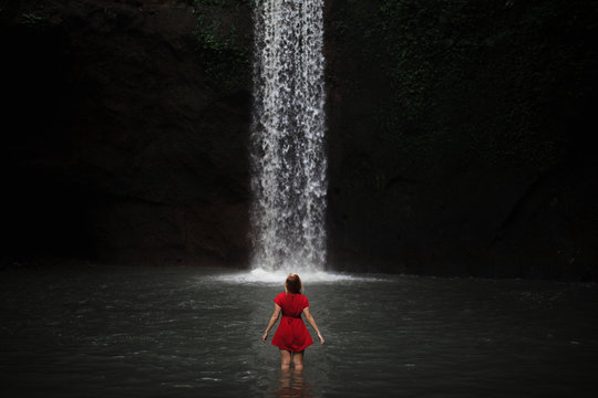 woman standing in-front of waterfall