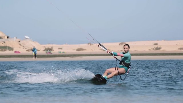 Young Woman Kitesurfing Towards Camera
