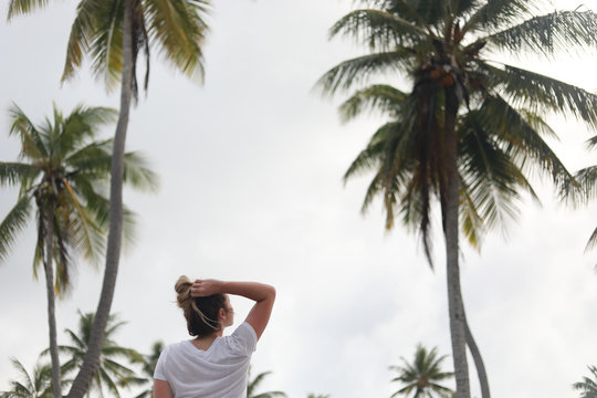 woman standing near palm trees