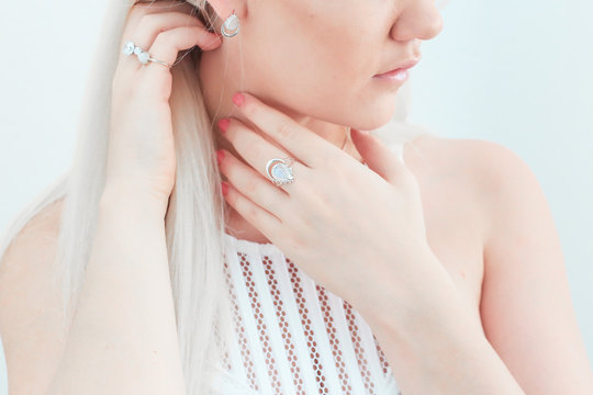 woman wearing jeweled gold-colored drop earrings and rings