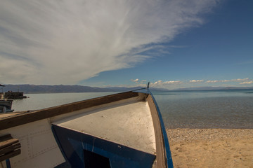 Landscape of Ohrid Lake with a boat and a fantastic cloud that harmonizes the composition of the...