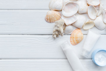 cosmetics with Dead Sea minerals and shells on white wooden background top view copy space