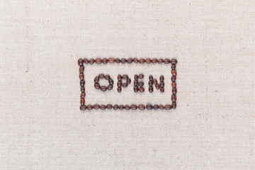 The word Open inside a rectangle written with coffee beans,aligned in the center,closeup.