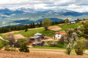 Fototapeta na wymiar Bulgarian village Bel Kamen in Rhodope mountain in front of snowy Rila peaks