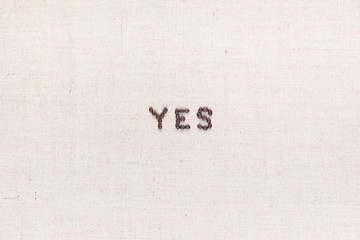 The word Yes written with coffee beans ,aligned in the center..