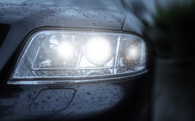 Car headlight. Wet car Headlamp close-up.