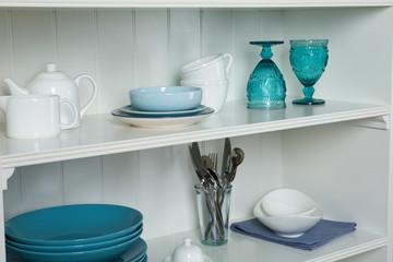 Fototapeta na wymiar White shelving unit with set of dishware