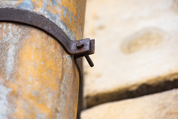Rusty bolt with mount on the drain pipe