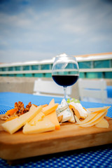 Assorted cheese and red wine on wooden platter
