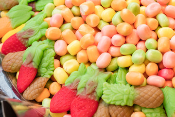 Multicolored lollipop, gummy candy in the shape of strawberries and pineapple. Copy space