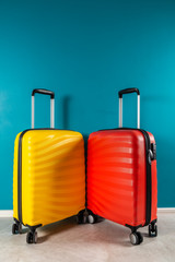 Bright and stylish cabin size suitcases as holiday concept agains dark blue background, copy space. Easy travel with little baggage