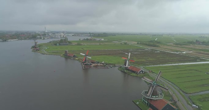 Wide aerial of riverside windmills, houses and waterways of Zaanse Schans North Holland Nederland Netherlands clean sustainable new energy