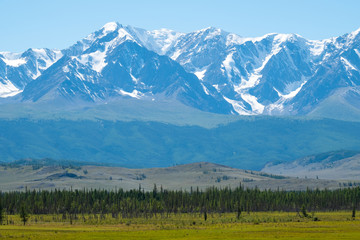 Snow capped mountains and hills with pine trees in Altai Republic, Russia
