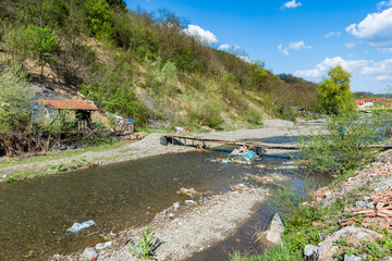 Krupanj, Serbia April 19, 2019: Likorda River in Western Serbia next to the city Krupanj. On the river there is a bridge made by hand. The river is polluted and full of garbage.