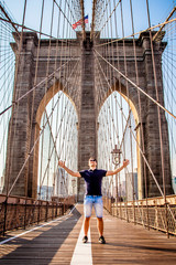 Tourist male model posing in front of Brooklyn Bridge